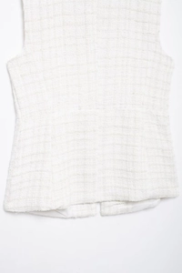 Detail of cream bouclé tweed texture on this sleeveless double-breasted vest for women