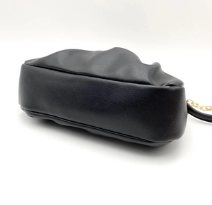 Detail view of the pleated black leather cloud bag with gold chain strap accents