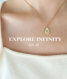 Close-up of a gold avocado pendant necklace with white enamel inlay on a female model