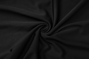 Close-up of soft black knitted fabric texture with elegant pleated spiral design detail