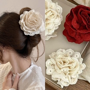 Detail of elegant lace flower hair claw clips in cream white and classic red colors