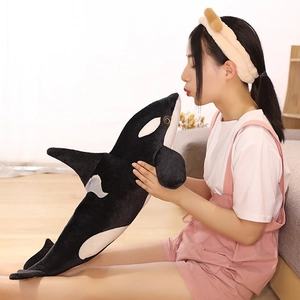 Detailed close-up of a soft plush orca whale toy featuring lifelike eyes and fins