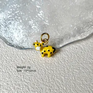 Close-up of a 10x13mm yellow cow enamel charm with black spots for jewelry making