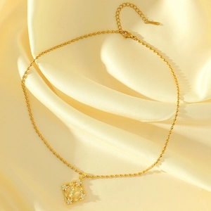 Gold beaded necklace featuring a diamond-shaped portrait pendant with small white flowers