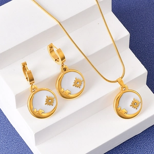 Golden sun and moon necklace set with matching earrings on geometric props