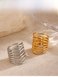 Close-up of multilayer wave open rings with hammered texture in gold and silver finish