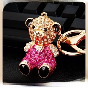 Macro shot of gold turtle keychain with champagne and rose rhinestones on black keyboard