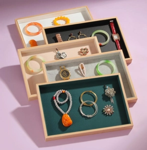Close-up of wooden jewelry display trays with various colored velvet linings and frames