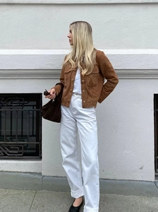 Chaqueta biker de ante marrón con pantalones vaqueros blancos de pernera ancha