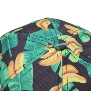 Detailaufnahme von tropischem Bananen- und Palmenprint auf schwarzer Basecap