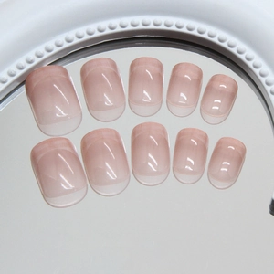French gradient nude pink press-on nails with a glossy finish on a mirror background
