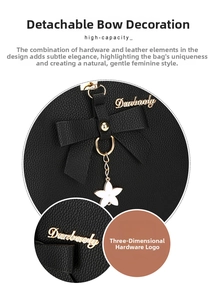 Detail view of black lychee leather handbag with a removable bow and gold flower charm