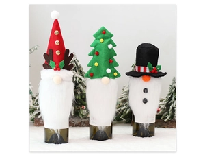 Three festive Christmas gnome and snowman wine bottle covers set on snowy surface