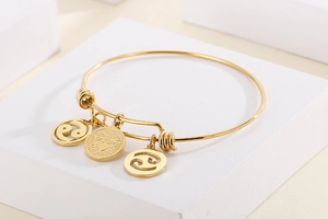 Detailed view of gold Cancer zodiac bracelet with crab charm and symbol pendants