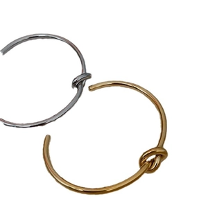 Minimalist knot cuff bangles in polished gold and silver finishes with an open design