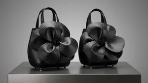 Detailed view of 3D leather flower design on bucket bag with drawstring satin lining