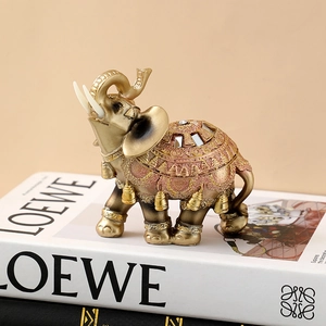 Detailed view of pink and gold resin elephant with gemstone inlay and ornate carvings