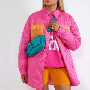 Giacca trapuntata rosa con tasche arancioni e borsa a tracolla blu su sfondo bianco