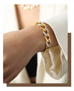 Detail of gold-plated Cuban chain bracelet with cubic zirconia on a female model