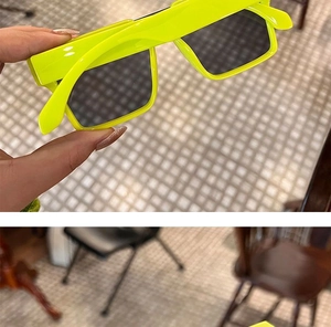 Detail shot of neon yellow rectangular punk sunglasses with black lenses in hand