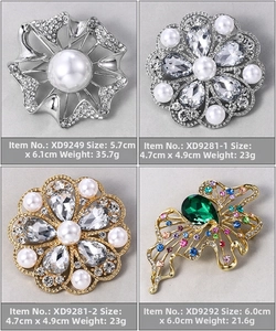 Detailed view of four vintage brooches with rhinestones and faux pearls in silver and gold