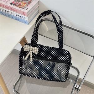 Close-up of black polka dot canvas tote bag featuring clear PVC pocket and checkered bow
