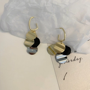 Detailed shot of vintage tassels earrings with gold and black discs on a white background
