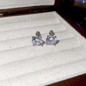 Close-up of sparkling round zircon stud earrings with classic four-prong setting