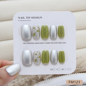 Short square press-on nails in translucent green glitter and metallic silver cat eye style