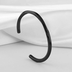 Polished black stainless steel C-shape twisted cuff bracelet on white silk background