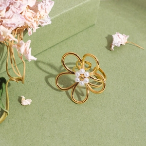 Bague fleur élégante en acier inoxydable doré 18K avec perle sur fond vert
