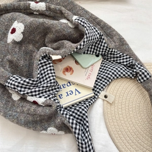 Close-up view of a fuzzy autumn tote bag featuring floral embroidery and checkered lining