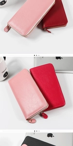 Detailed view of pink and red long zip wallets featuring classic litchi grain texture