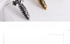 Macro detail of retro gothic cross pendant featuring silver and gold relief patterns