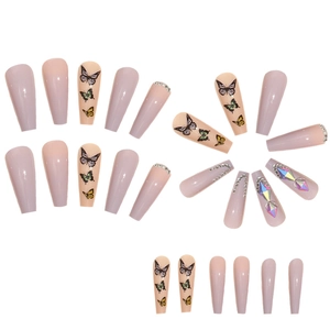Macro detail of long coffin false nails with purple glitter, rhinestones, and butterfly art