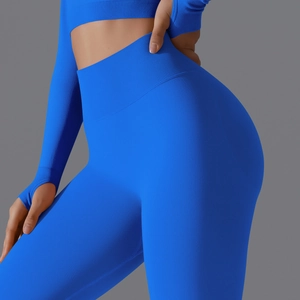 Detail of high-waist seamless bright blue leggings and long sleeve crop top with thumbholes