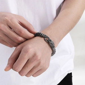 Gros plan du bracelet vintage en acier inoxydable avec motif écailles de serpent au poignet