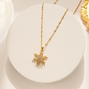 Détail d'un pendentif flocon de neige rotatif avec cristaux sur chaîne dorée