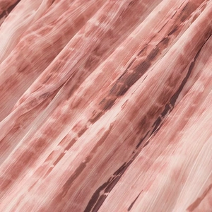 Macro del tessuto in chiffon tie-dye rosso e rosa di un abito lungo leggero