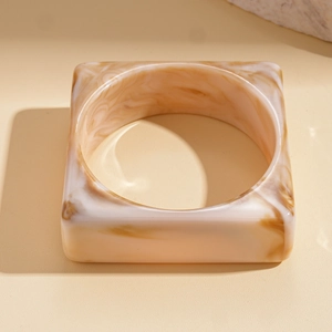 Detailed close-up of chunky square acrylic resin bangle with brown marble texture