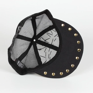 Detail of a black trucker hat featuring golden rivets on the brim and mesh back panel