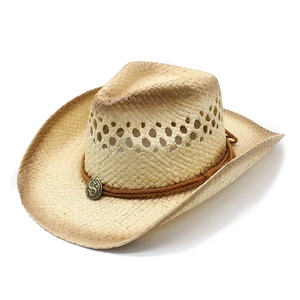 Dettaglio cappello di paglia western con stemma in metallo vintage, corda e fori d'aria
