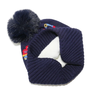 Detail of blue knitted kid's hat featuring warm white fleece lining and soft pom-pom