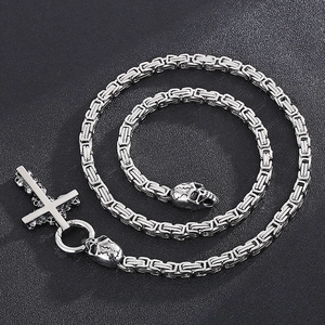 Detail of silver titanium steel cross pendant with skull motifs and Byzantine chain
