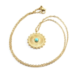 Detailed macro view of 18k gold plated sunburst pendant with center turquoise stone