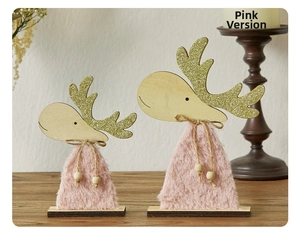 Close-up of pink plush reindeer figurines with golden glitter antlers and wood accents