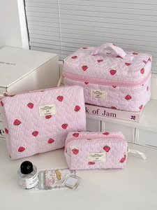 Detailed set of three pink striped quilted makeup bags with strawberry patterns