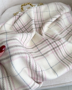 Close-up of beige plaid cashmere scarf texture with soft pink and khaki pattern details
