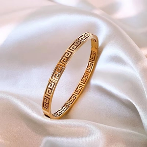 Vintage style gold titanium steel bangle with hollow geometric Great Wall pattern