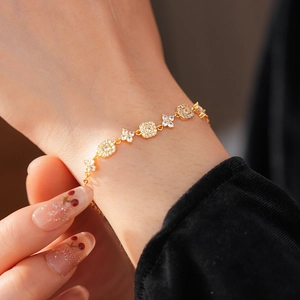 Macro shot of gold-plated square flower bracelet with sparkling cubic zirconia on wrist